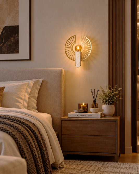 Solaris Wall Lamp — golden sunburst and globe above a bedside table | أبليك سولاريس، دائرة ذهبية مفتوحة وكرة مضيئة فوق طاولة بجوار السرير
