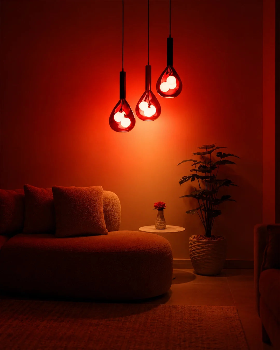 Grapa Pendant — three red glass pendants above seating | دلاية جرابا، ثلاث دلايات زجاجية حمراء فوق منطقة جلوس