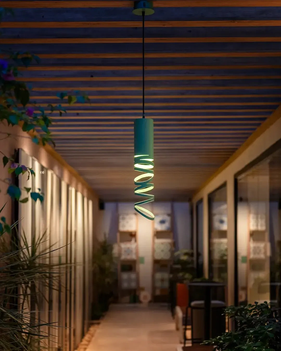 Whirl Pendant in a styled interior, pendant with an animated sense of rotation (view 1) | دلاية ويرل، داخل مساحة منسقة، انحناءات معدنية وإضاءة خفيفة