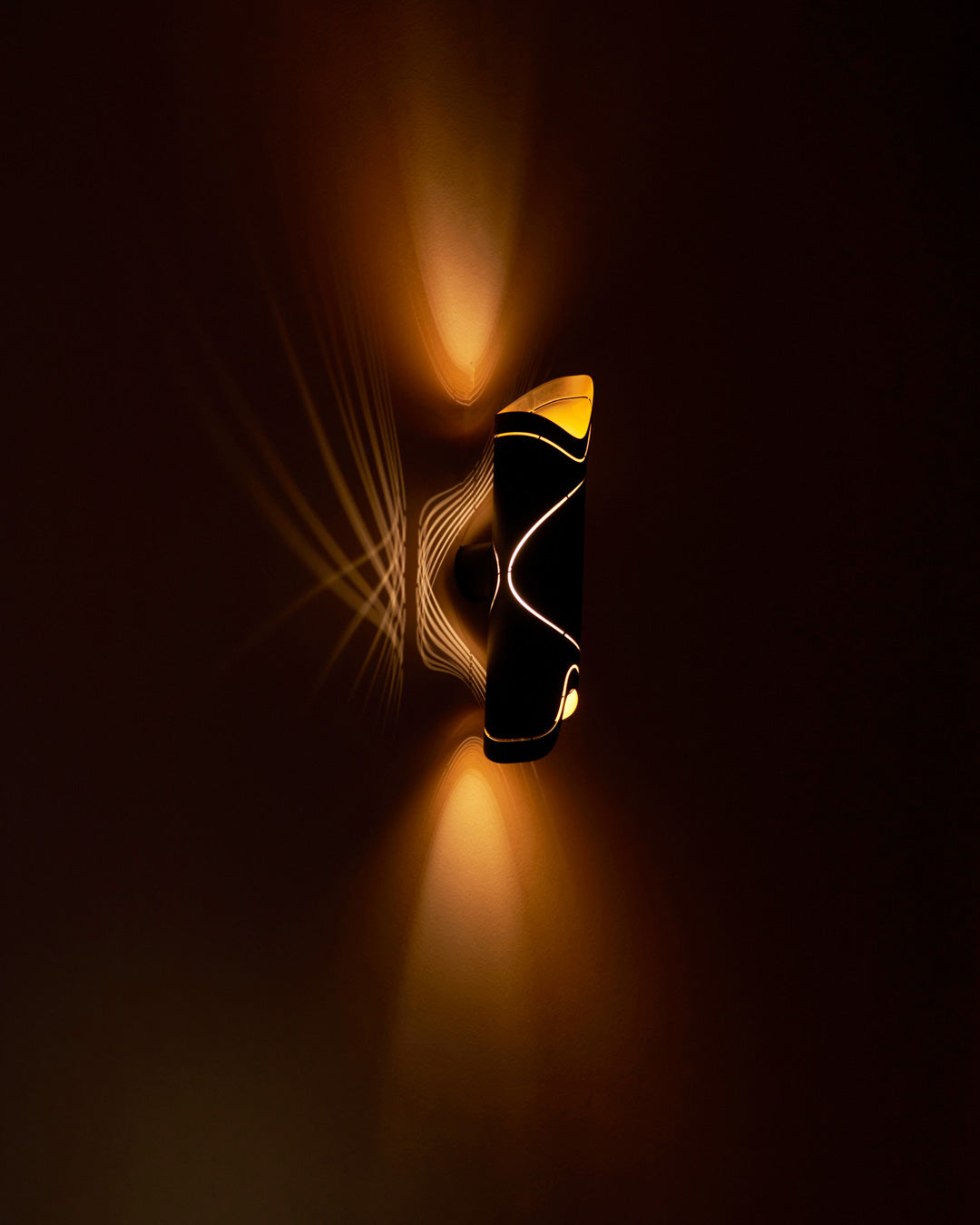 Waves wall lamp with flowing sand wave texture casting soft ambient light / مصباح حائط بتصميم تموجات رملية يوزع إضاءة ناعمة وهادئة على الجدار
