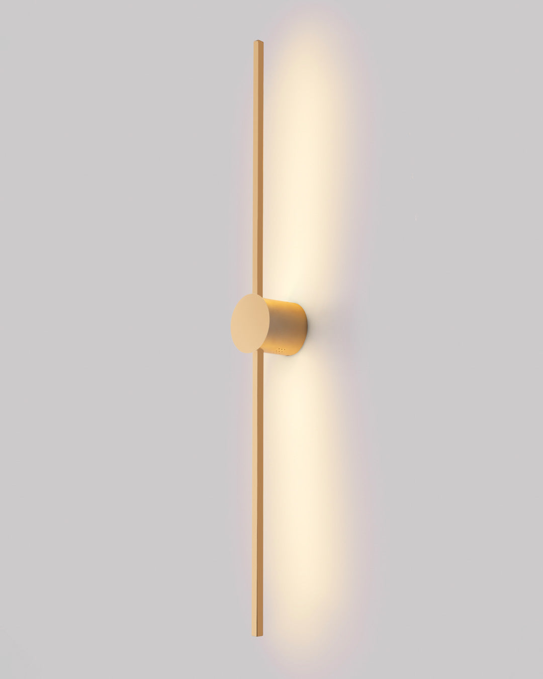 Gold wall lamp with double vertical lines and central circle casting soft indirect light / مصباح حائط ذهبي بخطين رأسيين ودائرة مركزية يبعث إضاءة غير مباشرة ناعمة