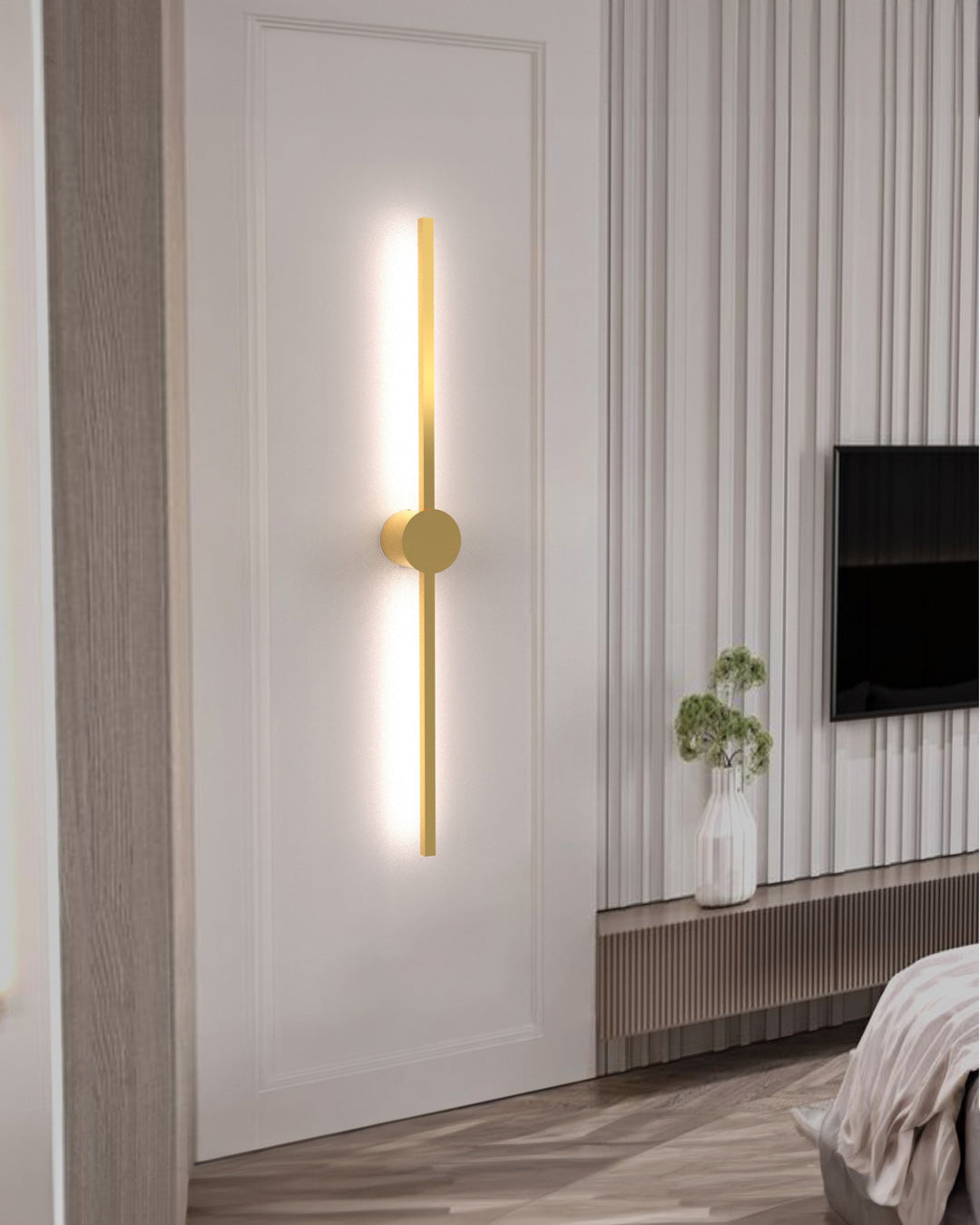 Gold wall lamp with double vertical lines and central circle casting soft indirect light / مصباح حائط ذهبي بخطين رأسيين ودائرة مركزية يبعث إضاءة غير مباشرة ناعمة
