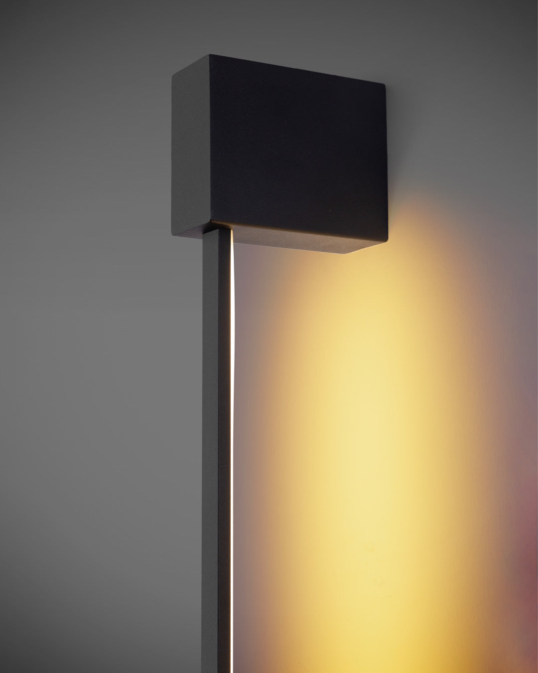 Black square wall lamp with linear design casting soft indirect light / مصباح حائط أسود مربع بخطوط هندسية يبعث إضاءة غير مباشرة ناعمة